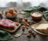 Eiweissreiche Lebensmittel: Eier, Fleisch, Nuesse, Kaese und Quark auf Holztisch
