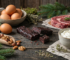 Proteinquellen im Vergleich: Snack, Eier, Fleisch, Nuesse und Quark auf Holztisch